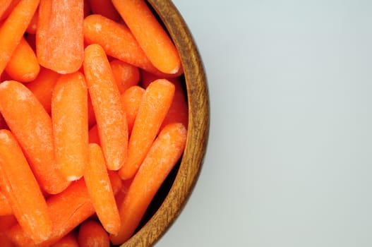 Fresh Small Orange Carrots in Wood Bowl.