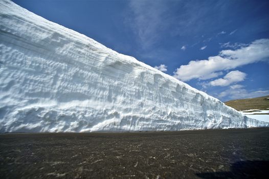Large Snowfields in Colorado Mountains. Early Spring in the Rocky Mountains National Park (USA). Pavement Level Shot.