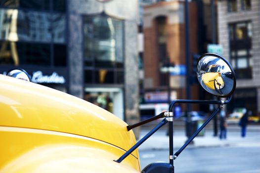 School Bus Mirror. Yellow School Bus in the Mirror in Downtown Chicago. American School Transportation System.