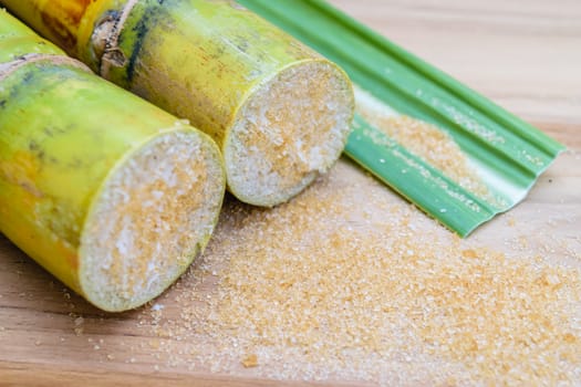 brown sugar and sugarcane on wooden table