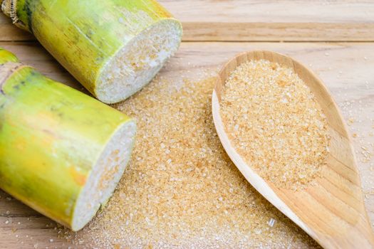 brown sugar and sugarcane on wooden table