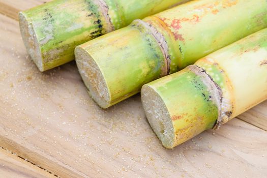 brown sugar and sugarcane on wooden table