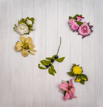 From above different colored artificial flowers on a white wooden board in Ukraine