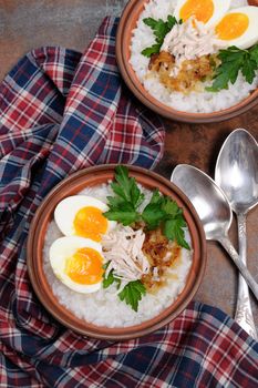 Rice porridge ginger congee with egg, chicken, crispy shallots and parsley
