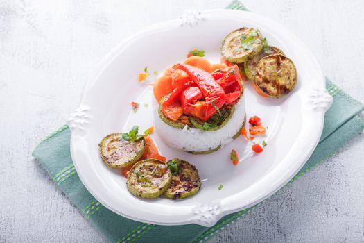 Rice timbale with fried zucchini peppers, carrots