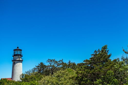 The Highland Light at Truro on Cape Cod stands out against a clear bue sky.
