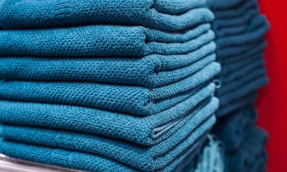 Blue towels on the shelf in the closet.