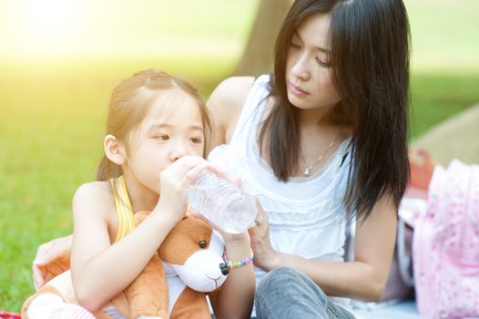 Asian mother comforting her crying child in the park, Family outdoor lifestyle.