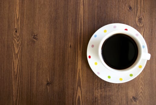 Black coffee cup on old wooden table top view background.