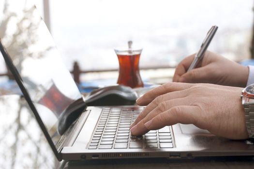 Close-up view of the hands on the keyboard while working with a businessman laptop.