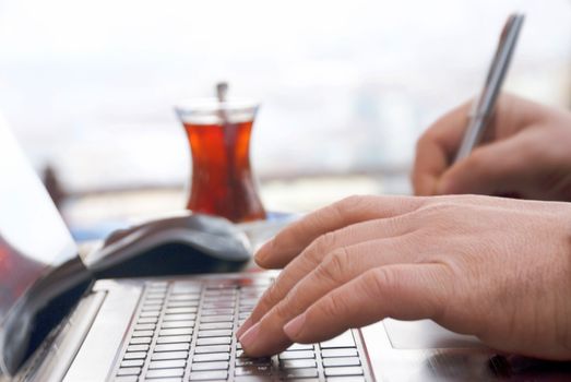 Close-up view of the hands on the keyboard while working with a businessman laptop.