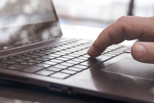 Close-up view of the hands on the keyboard while working with a businessman laptop.