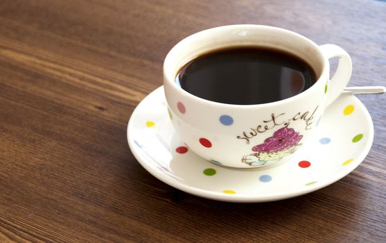 Black coffee cup on old wooden table top view background.