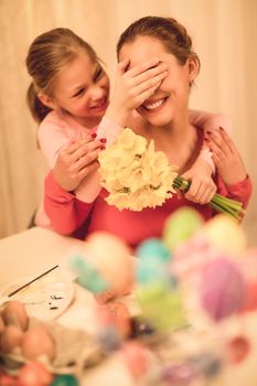 Cute little girl surprise her mother with bouquet yellow daffodils. Selective focus. 