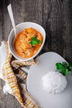 Chicken curry and rice served on a wooden surface