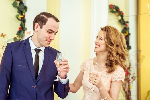 Man and woman drinking champagne in the registry office during the ceremony in Lviv, Ukraine