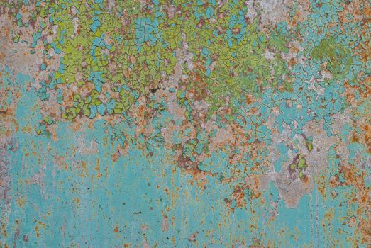 fragment of a rusty iron surface covered with old paint, which has long been under the influence of different climatic conditions