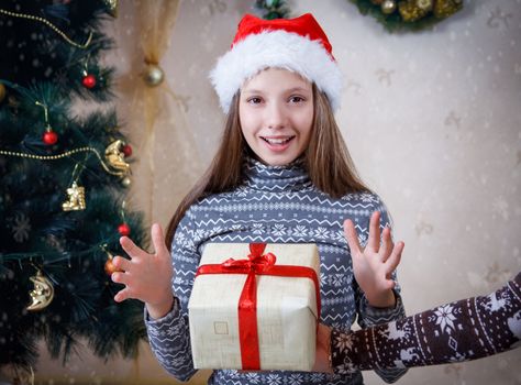 Surprised girl receiving Christmas gift, focus on girl
