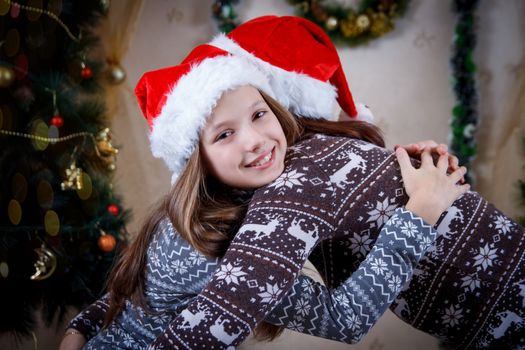 Mother hugging daughter in Christmas hats