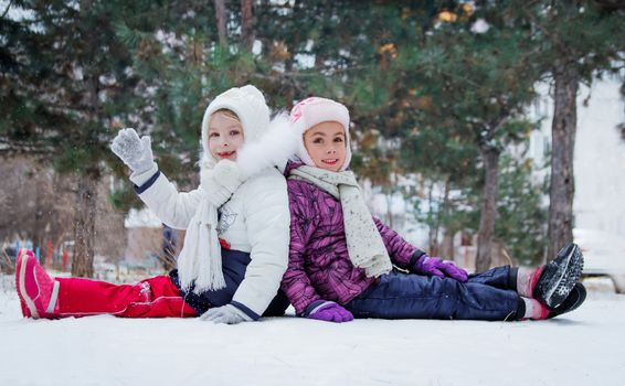 Two cute girls having fun among winter park