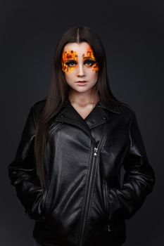 Portrait of a girl with an original make-up. Beauty close-up with orange and red rhinestones on a face of the model