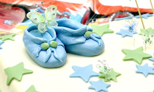 Celebrating baby boy first birthday, cute sweet shoes on a cake