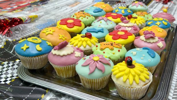 colorful cupcakes with various decorations, shallow dof