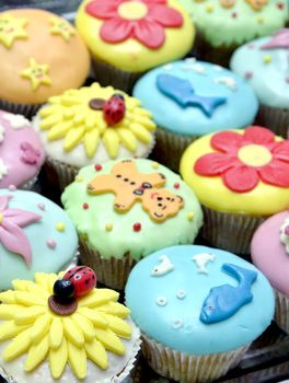 colorful cupcakes with various decorations, shallow dof