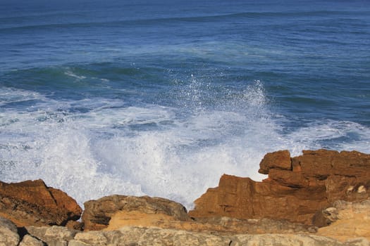 Marine wave breaks against offshore stone