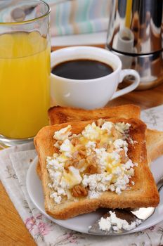 Crisp, fresh  toast ricotta, honey and nuts for breakfast with orange juice and coffee