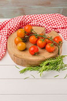Organic cherry tomatoes with rosemary on rustic wooden table