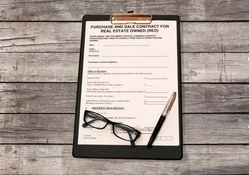 Form of contract with a black pen on a wooden table made of grey Board