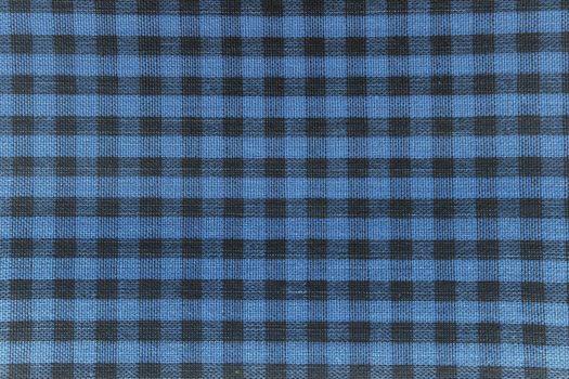 The texture of checkered fabric as a background. Checked fabric tablecloth. Fabric in a small square. Texture plaid fabric. Texture background of kitchen towels