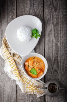 Chicken curry and rice served on a wooden surface