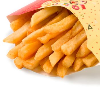 close up view of french fries in colorful cartoon box. Isolated on white with clipping path. Copy space.