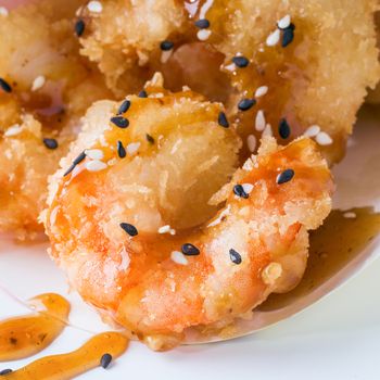 Close up view of fried tempura shrimps in paper box. isolated on white