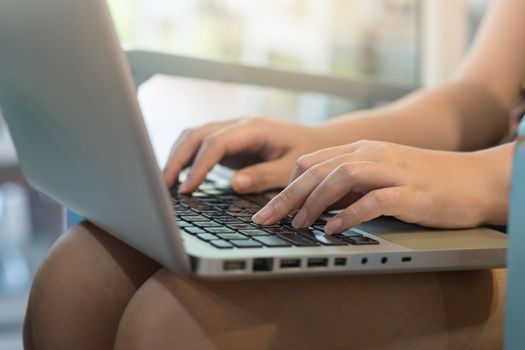 Woman hand typing on laptop computer keyboard for online business. work from anywhere concept