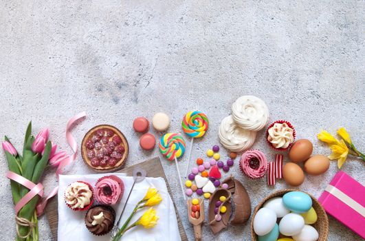Selection of easter sweets, bakery cupcakes, chocolate eggs and confectionery with copy space 