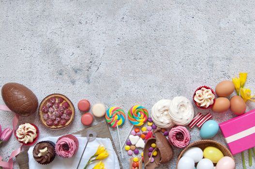 Assorted easter sweets, bakery cupcakes, chocolate eggs and confectionery with space