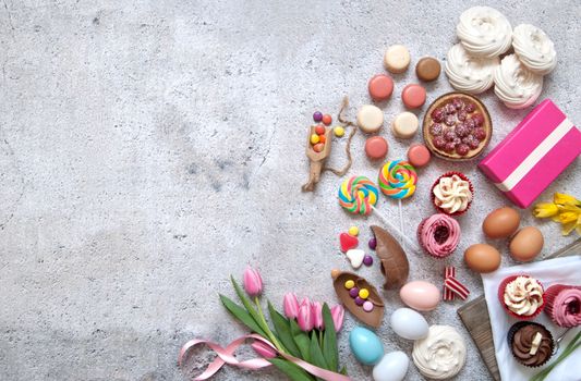 Assorted easter sweets, bakery cupcakes, chocolate eggs and confectionery with space 