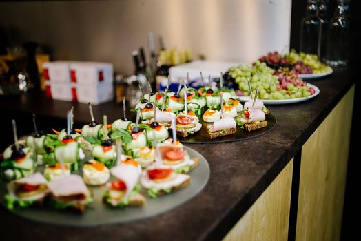 Canape with ham, tomato and cucumber on the bar