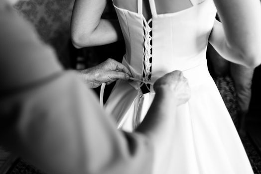 Mother laces bride dress