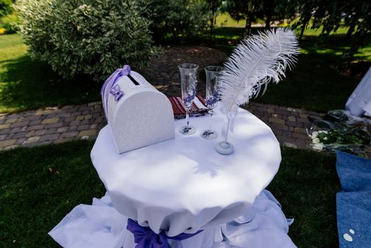 Wedding box, glasses, pen and towel on a table outdoors