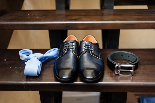 Groom shoes, tie and on belt the stairs