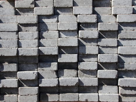 Uneven Stack of Grey Concrete Road Bricks Background