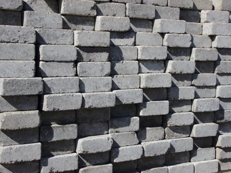 Uneven Stack of Grey Concrete Road Bricks Perspective Background