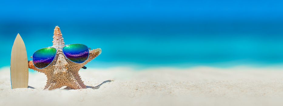 Starfish in sunglasses with surfboard on beach, holiday in beach concept