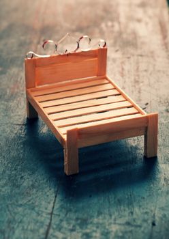 Amazing miniature handmade product for interior design, mini furniture make from wood stick on wooden background, small bed so cute, a hobby leisure