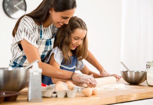 Shot of a mother and daughter having fun in the kitchen and learning to make a cake