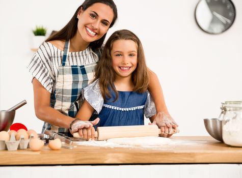 Shot of a mother and daughter having fun in the kitchen and learning to make a cake